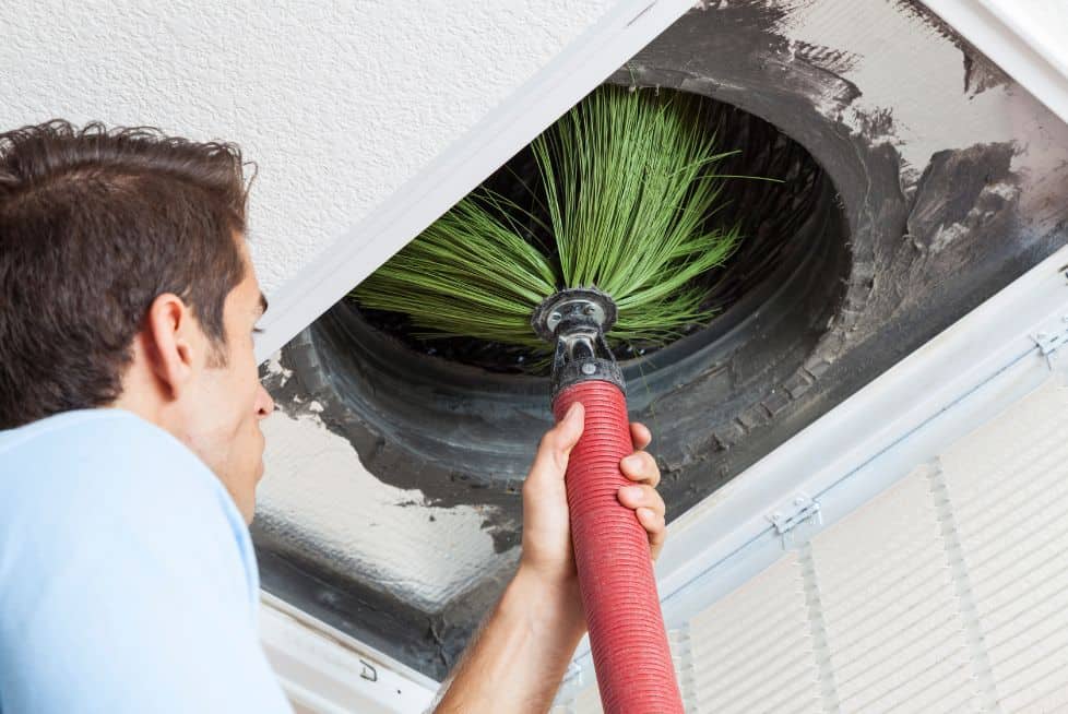 an image of a man cleaning air duct